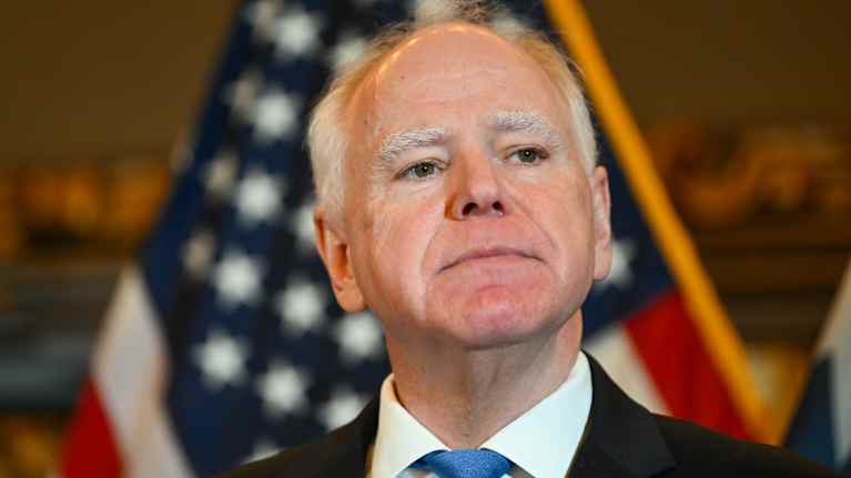 Mies seisoo lipun edessä.