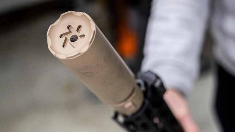 Ase Utran valmistama äänenvaimennin aseeseen kiinnitettynä.