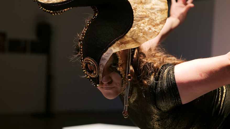 Tanssija esiintyy ja katsoo kameraan.