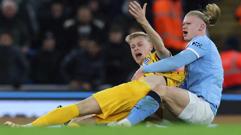 Manchester Cityn kärkimies Erling Haaland (oik.) painii nurmenpinnassa Brightonin hollantilaispuolustaja Jan Paul van Hecken kanssa. 