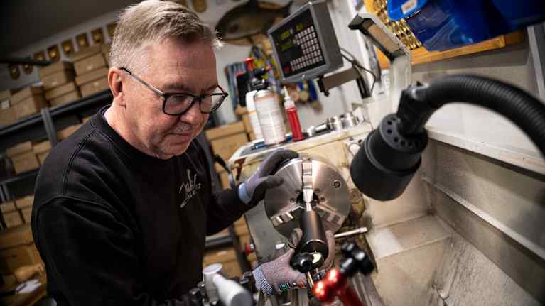 Jussi Nyyssönen tarkastaa äänenvaimentimen suoruuden.