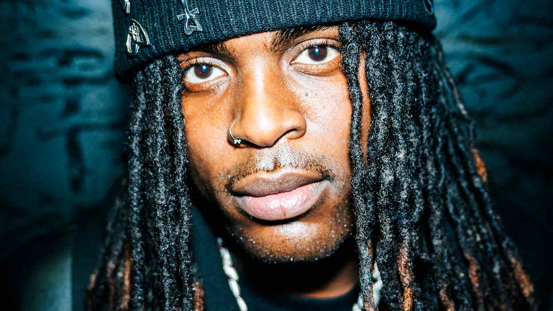 Henkilöllä yllään musta takki ja huppari.