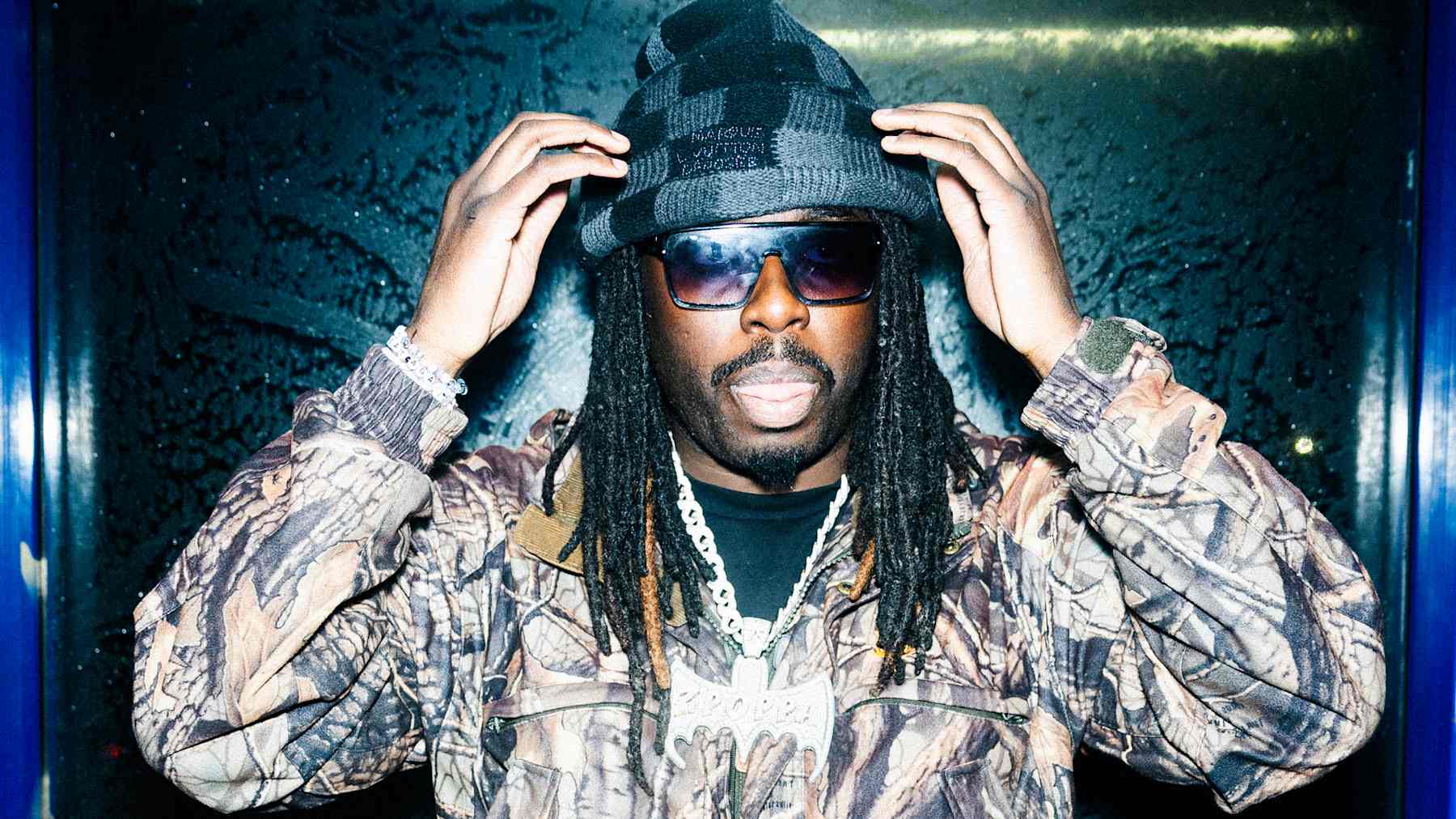 Henkilö pukeutuneena kuvioituun takkiin ja tummaan pipoon.