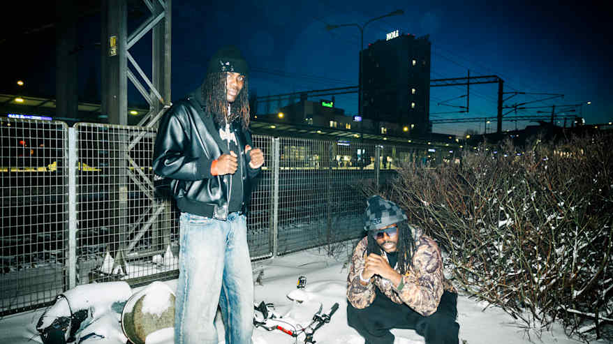 Kaksi henkilöä ulkona urbanissa talvisessa ympäristössä.