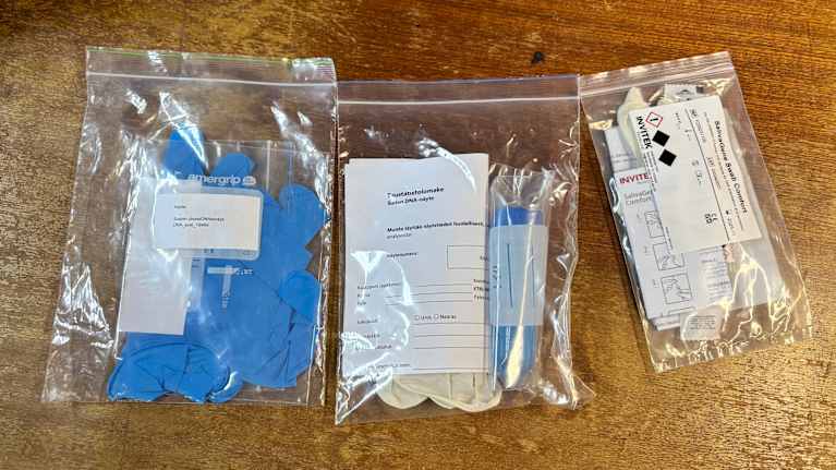 Pusseja joissa on näytepulloja, sinisiä kumihanskoja ja ohjepapereita.