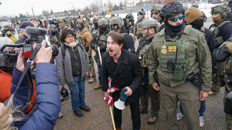 Mielenosoittajia ja poliiseja.