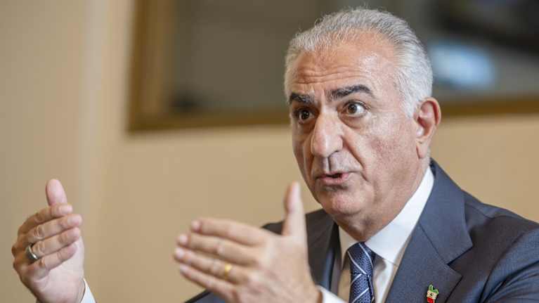 Reza Pahlavi puhuu ja elehtii käsillään.