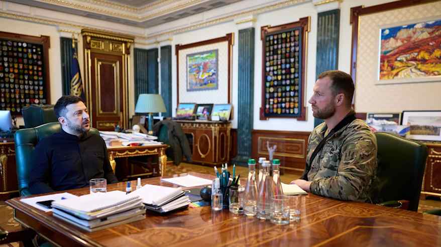 Kaksi henkilöä keskustelee päydän äärellä.