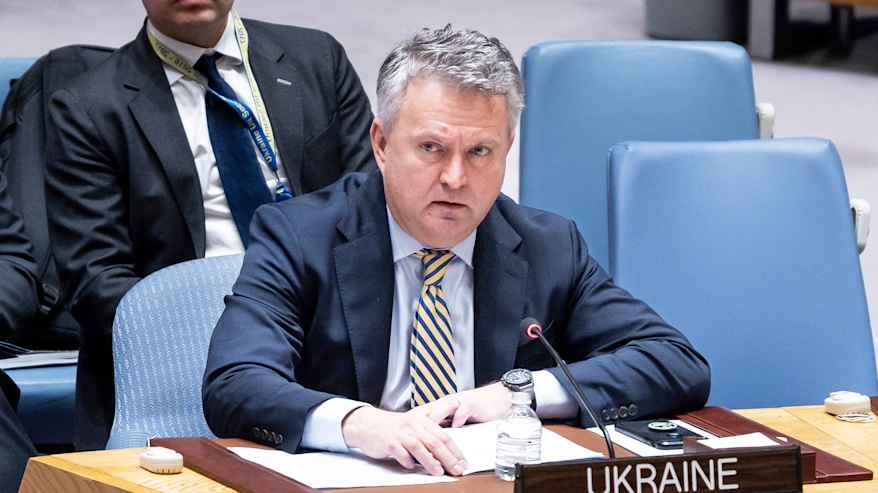 Henkilö istuu YK:n istuntosalissa.