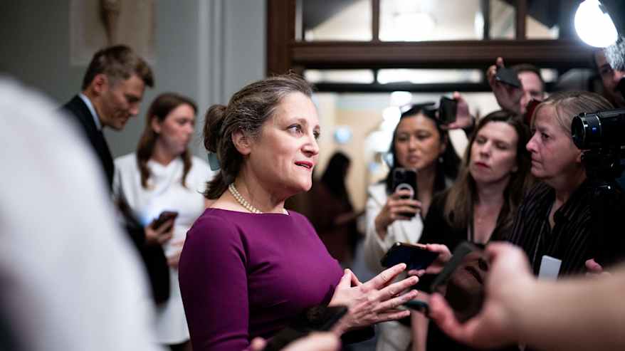 Henkilö puhuu ryhmälle median edustajia.