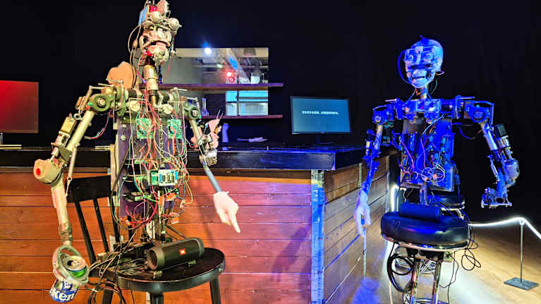 Robotit istuvat vierekkäin baaritiskin äärellä.