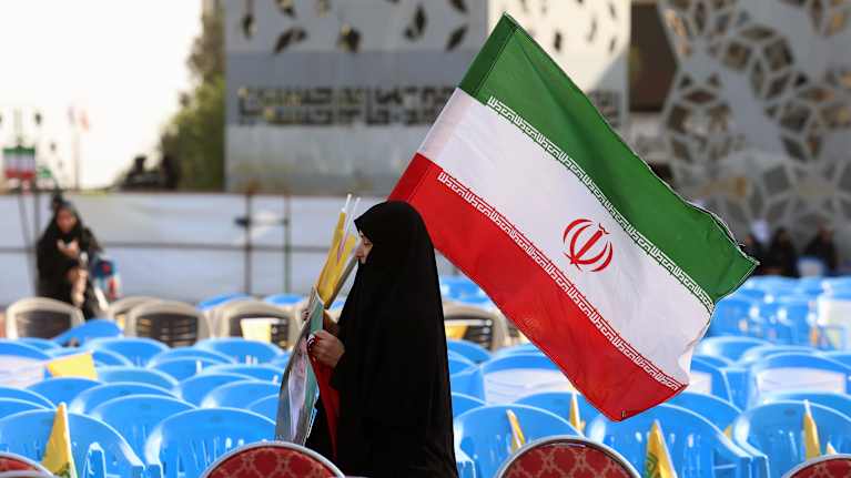 Nainen kantaa Iranin lippua.