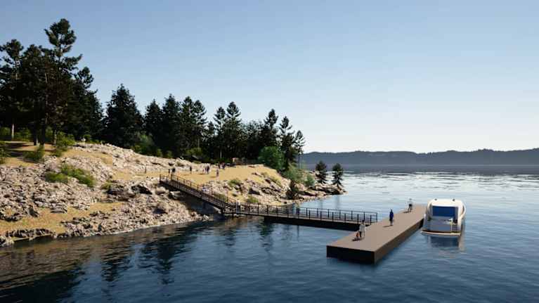 Havainnekuvassa näkyy laituri ja Karhusaaren rantaa aurinkoisena kesäpäivänä.