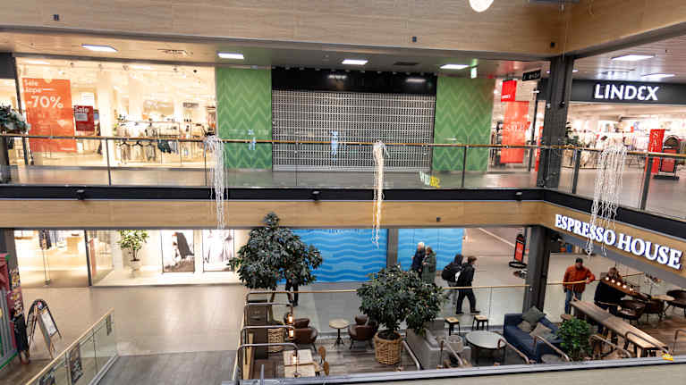 Tyhjiä liiketiloja kauppakeskuksessa. Etualalla kahvila.