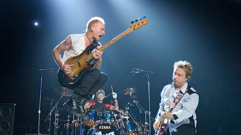 Sting, Andy Summers ja Stewart Copeland esiintyvät lavalla.
