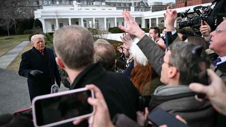 Trumpin ympärillä parveilee lehdistöä.