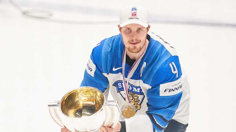 Mikko Lehtonen nostaa MM-pokaalia mitali kaulassa.