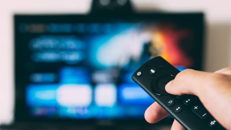 Kädessä oleva kaukosäädin osoittaa televisiota.