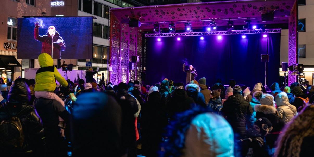 Lasten uusivuosi -tapahtuma Rotuaarilla, etualallayleisöä, taustalla Rotuaarin lava, jossa puhuja