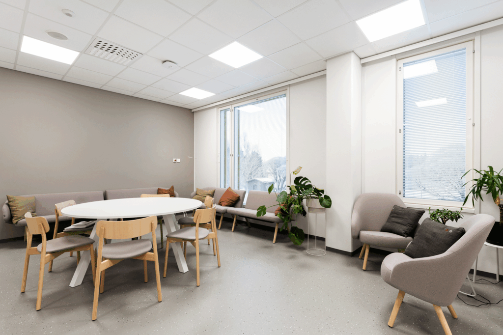 Nojatuoleja, sohva, pöytä ja tuoleja huoneessa.