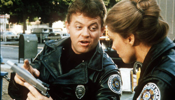 Tackleberry esitteli mielellään isoja aseitaan. Kuva elokuvasta Poliisiopisto II: Eka komennus (1985).