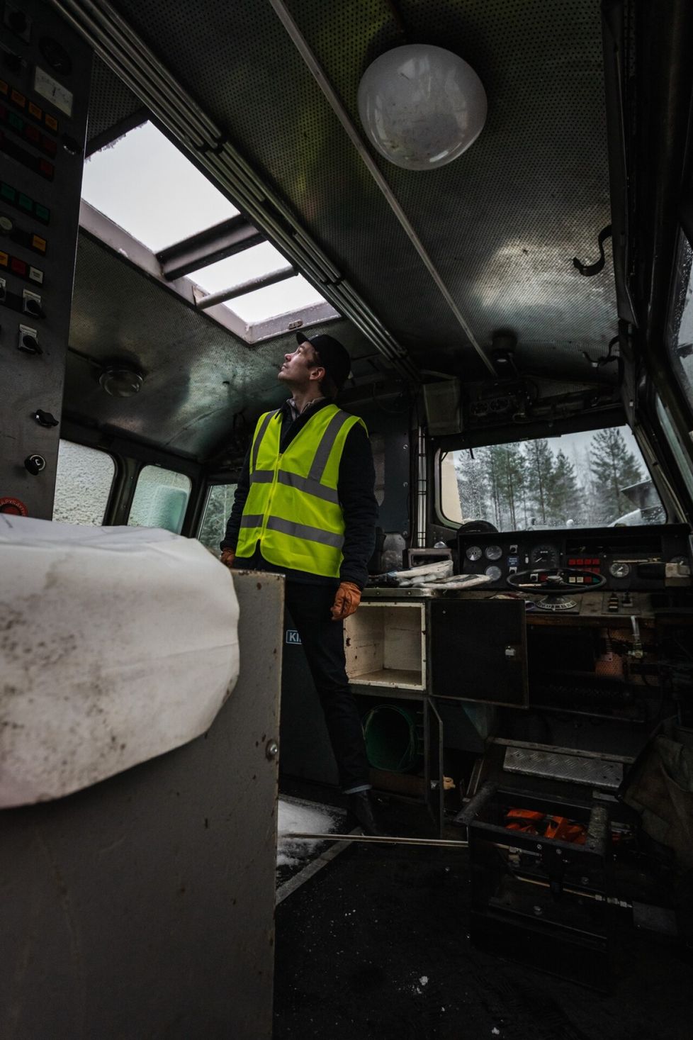 Kalustojohtaja Joonas Roivainen katselee taivaalle DV12-veturin ohjaamon kattoikkunasta.