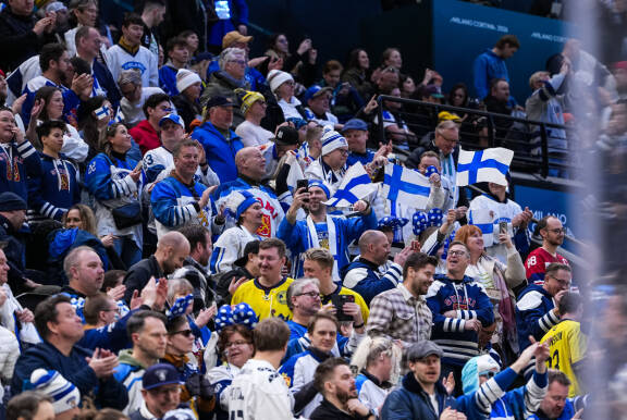 Suomalaisyleisöä Milano-Cortinan Olympialaisten jääkiekkopelin katsomossa.