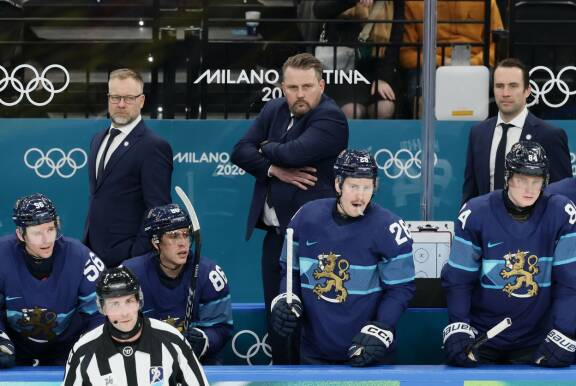 Suomalaispelaajia ja valmennusryhmä vaihtopenkillä.