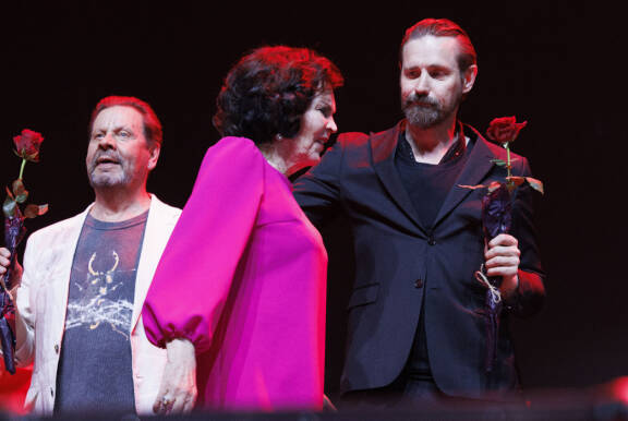 Paula Koivuniemi Kiitos Paula -konsertissa vuonna 2024. Vierellä Lauri Tähkä ja taustalla Pate Mustajärvi.