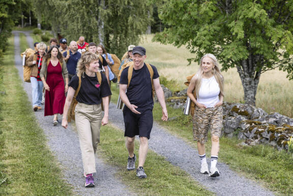 Farmi Suomen kilpailijat kävelevät tietä pitkin.