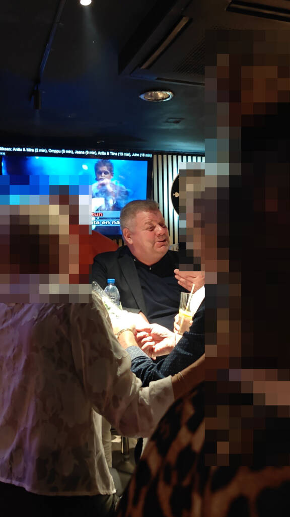 Jari seurusteli pöydässä karaokejonon edetessä.