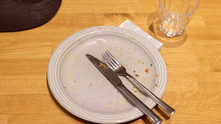 Tyhjäksi syöty ruokalautanen ruokapöydällä.