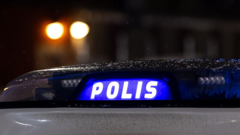 Poliisiauton vilkkuva valokyltti pimeässä yössä.