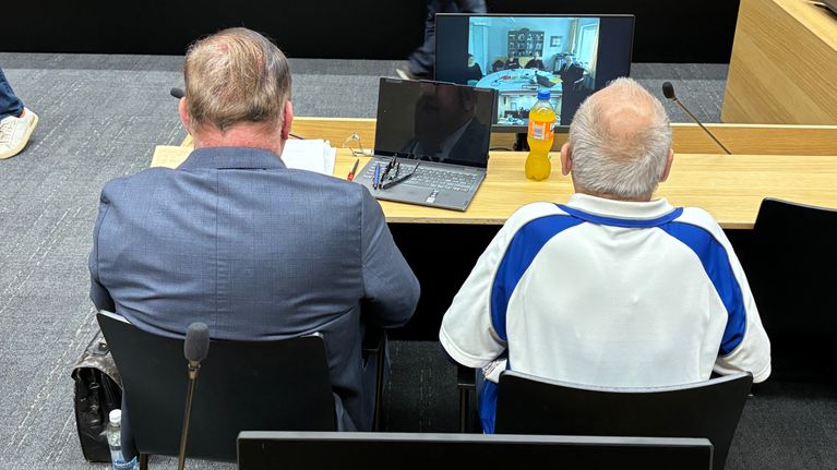Taivalkosken kylätalomurhasta syytetty oikeudessa kuvattuna takaapäin. 