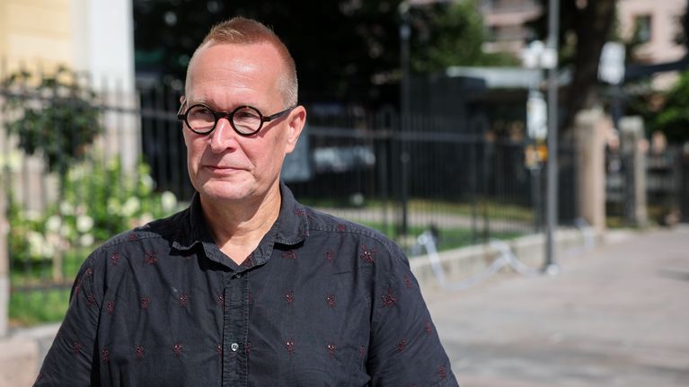 Mies seisoo Turun keskustassa aurinkoisessa säässä.