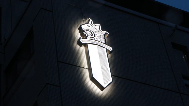 Poliisin valaistu tunnus Helsingin poliisilaitoksen seinässä.