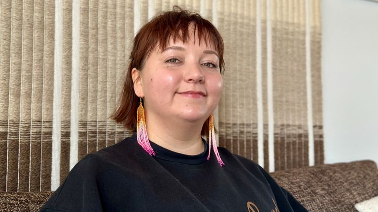 Nainen istuu sohvalla. Henkilökuva. Sunna Nousuniemi. 