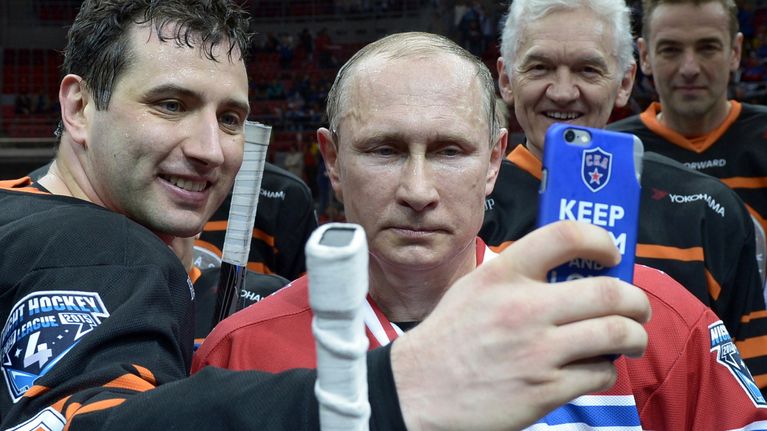 Roman Rotenberg (vas.) hymyili yhteiskuvassa Vladimir Putinin kanssa Sotshissa järjestetyssä jääkiekkoturnauksessa vuonna 2015.
