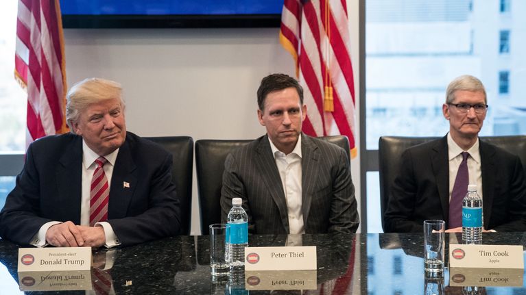 Donald Trump, Peter Thiel ja Tim Cook istuvat vierekkäin pöydän ääressä.