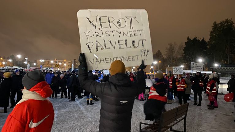 Ihmisiä Varkauden sairaalan pihalla mielenilmauksessa.