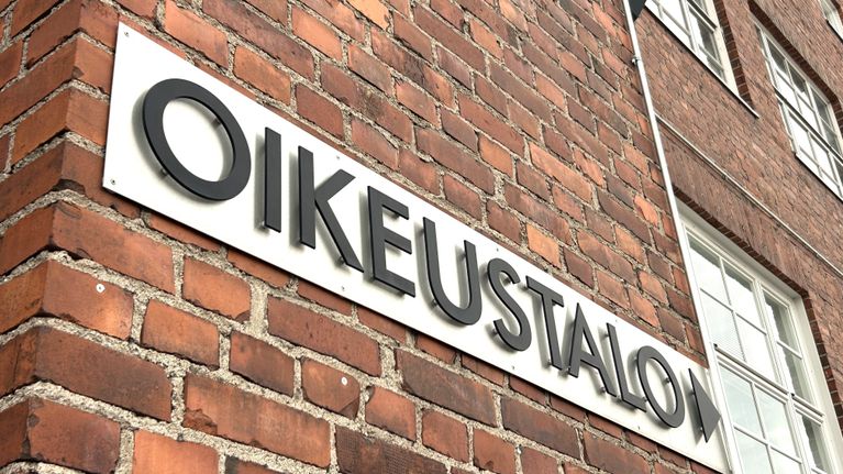 Punatiilisen rakennuksen seinässä lukee valkoisella pohjalla mustin kirjaimin: Oikeustalo.