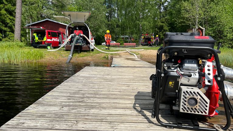 Pelastuslaitoksen väkeä hakemassa vettä lammesta tulipalon sammuttamista varten.
