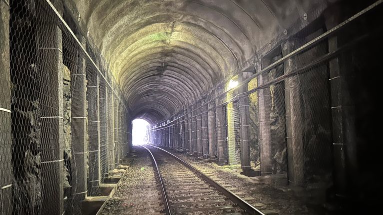 Möykynmäen rautatietunneli sisältä päin kuvattuna, tunnelissa rautatiekiskot.