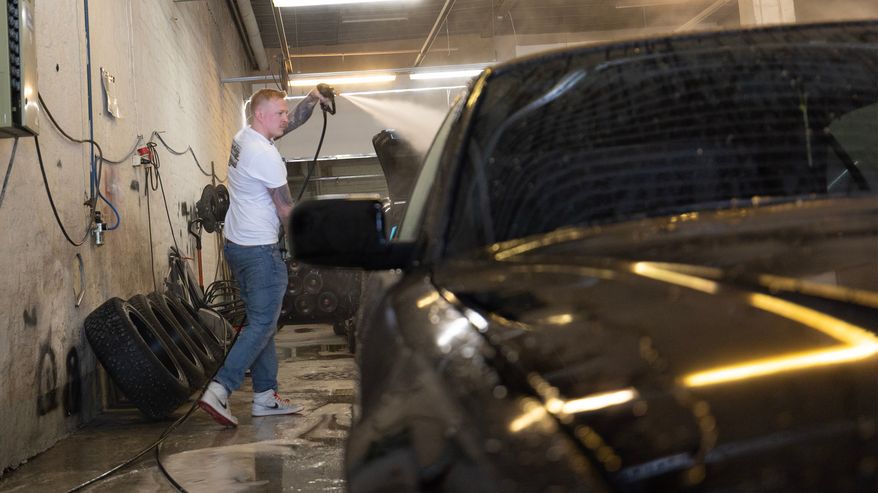 Emppu Pietikäinen pesee autoa.
