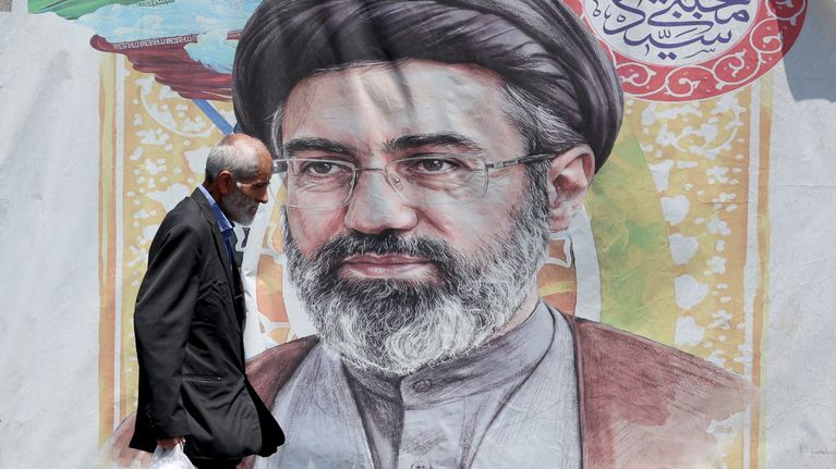 Mies kävelee Ajatolla Mojtaba Khameneita esittävän julisteen ohi Teheranissa 18. kesäkuuta 2026.