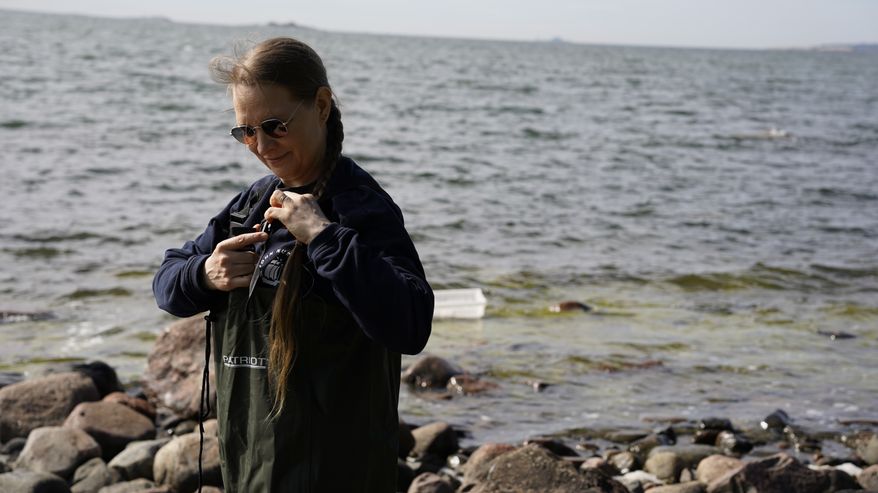 Meribiologi Miina Mäki pukee ylleen kahluusaappaita.