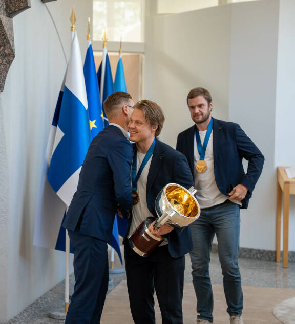 Alexander halasi joukkueen jäsenet läpi. Kuvassa presidentti syleilee Mikael Granlundia, taustalla joukkueen kapteeni Alexander Barkov.