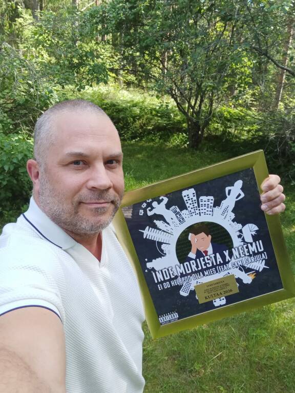 Sami Sarjula poseeraa kultalevy kainalossaan