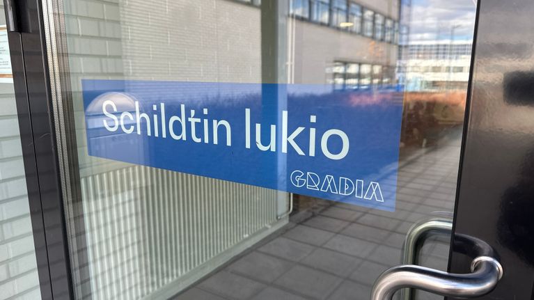 Schildtin lukion ulko-ovi, jossa lukion nimitarra.