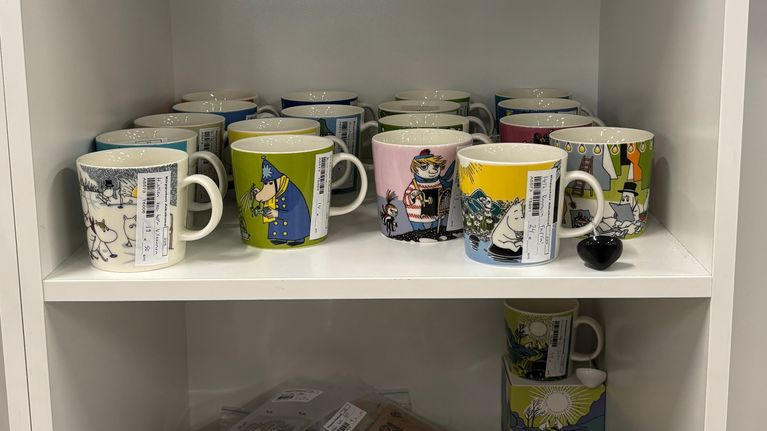 Muumimukeja hyllyllä kirpputorilla.